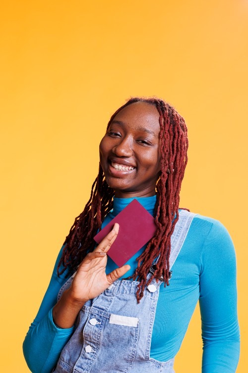 smiling-girl-holding-travelling-passport-2023-11-27-05-02-57-utc